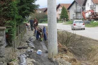 Pješački prijelaz na mostu; rasvjetni stupovi posred nogostupa